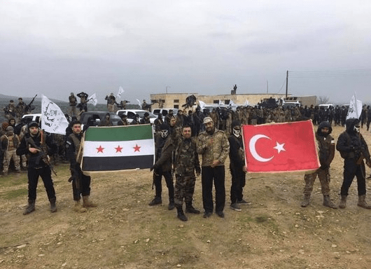 An Islamist militia takes down the Turkish flag from its headquarters in the occupied Afrin