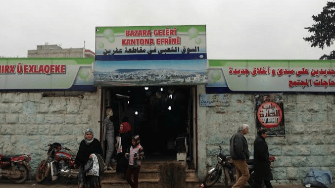 Forcing the Kurdish street vendors to remove their stalls and allow the settlers to spread them on the Raju road in the center of Afrin