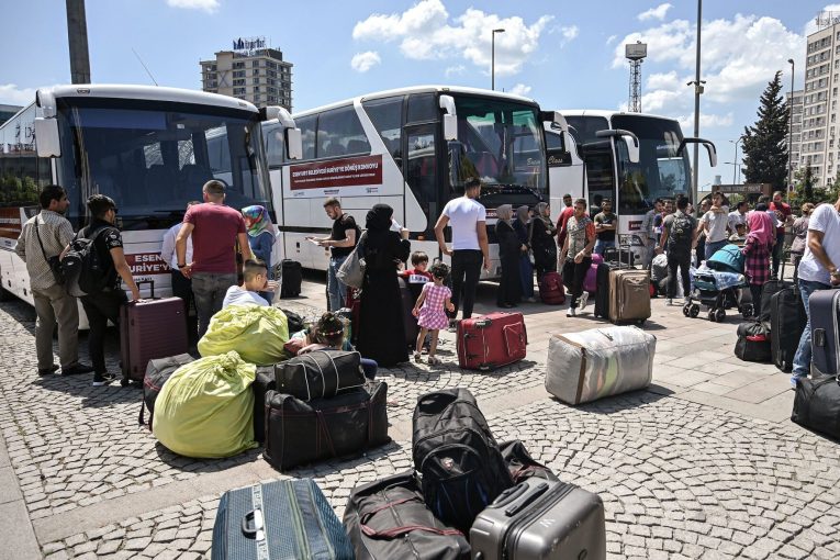 Forcibly deported from Turkey, a person arrives at his village in Afrin, Syria